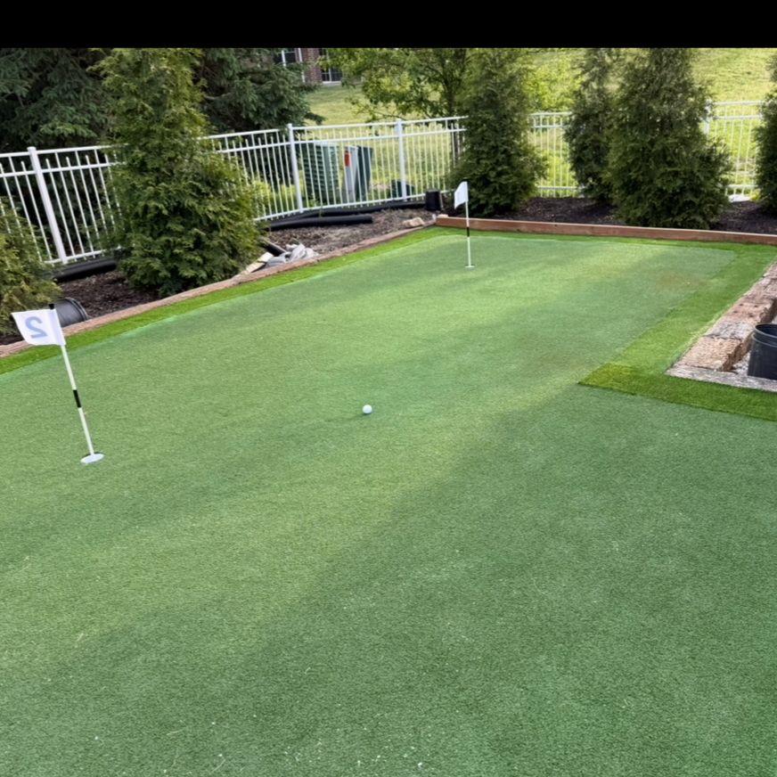 Backyard putting green install with flags